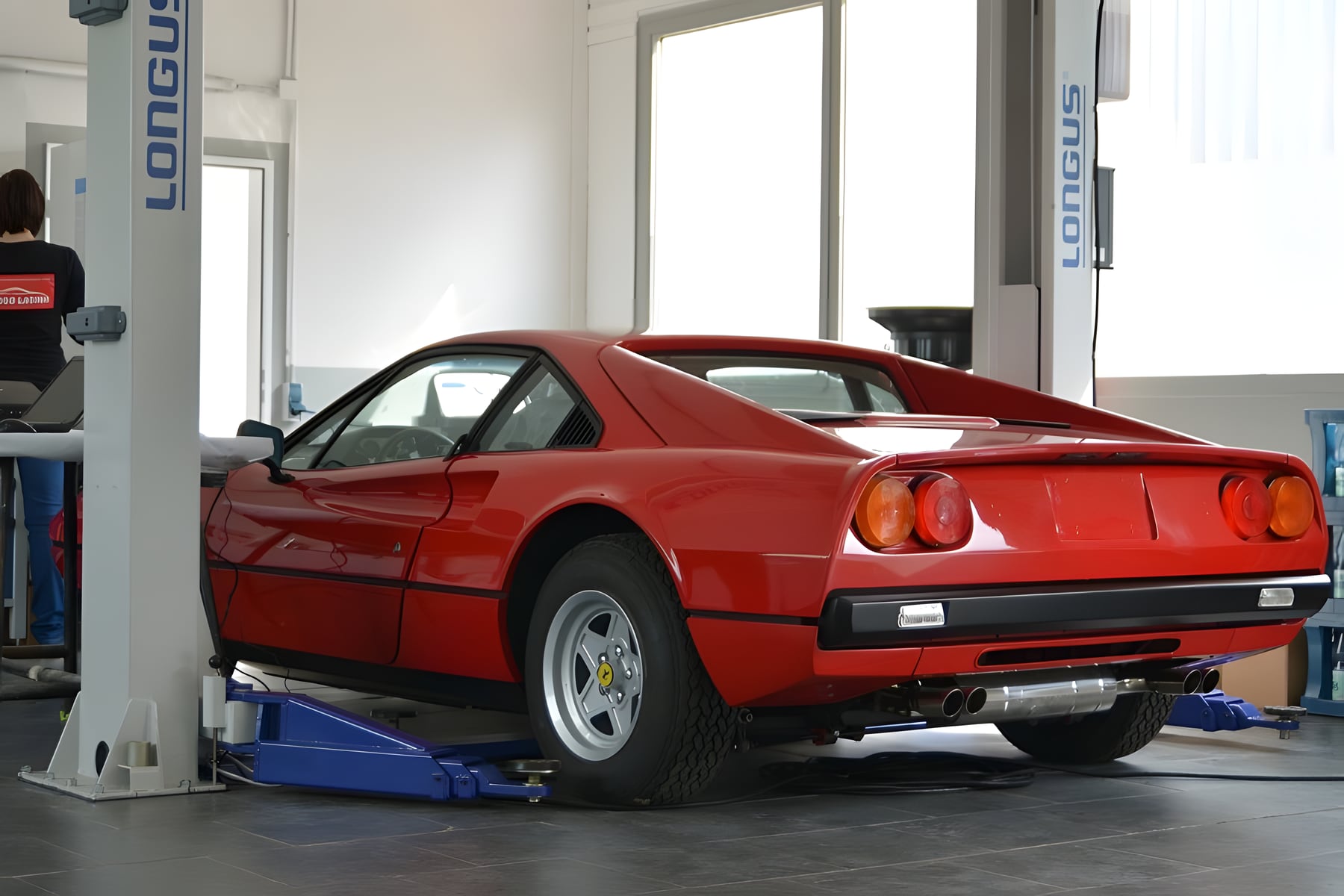 Roter Ferrari 308 auf der Hebebühne in der Werkstatt